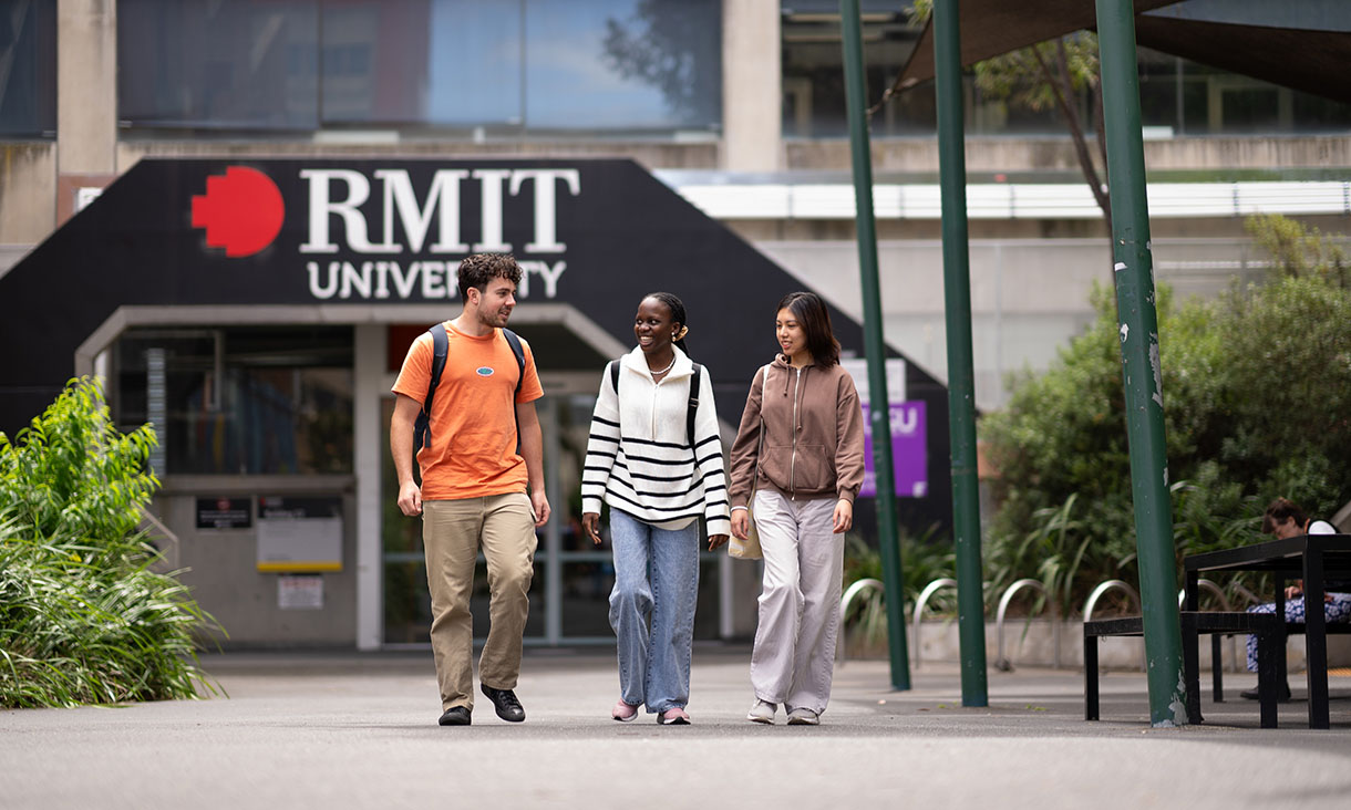 Three RMIT students walk with each other on campus.