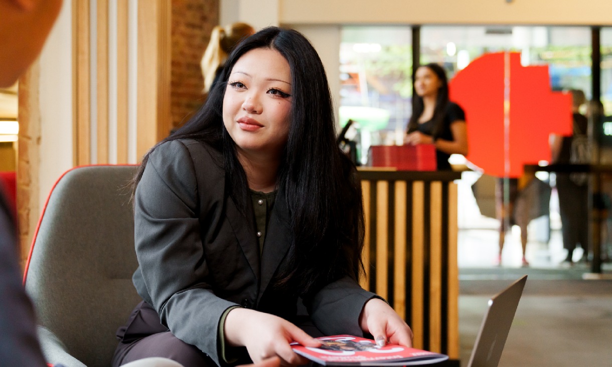 Woman leaning forward on chair engaging in a conversation. 