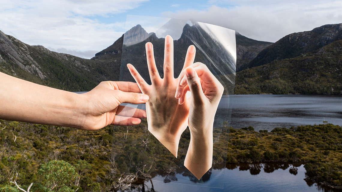 Two women stand in front of a wall of photography prints. Works by Yueran Li, photo by Pia Johnson.