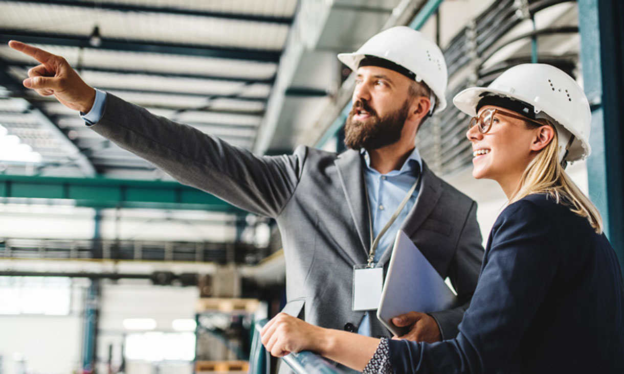 Two engineers wearing hardhats at a job site.