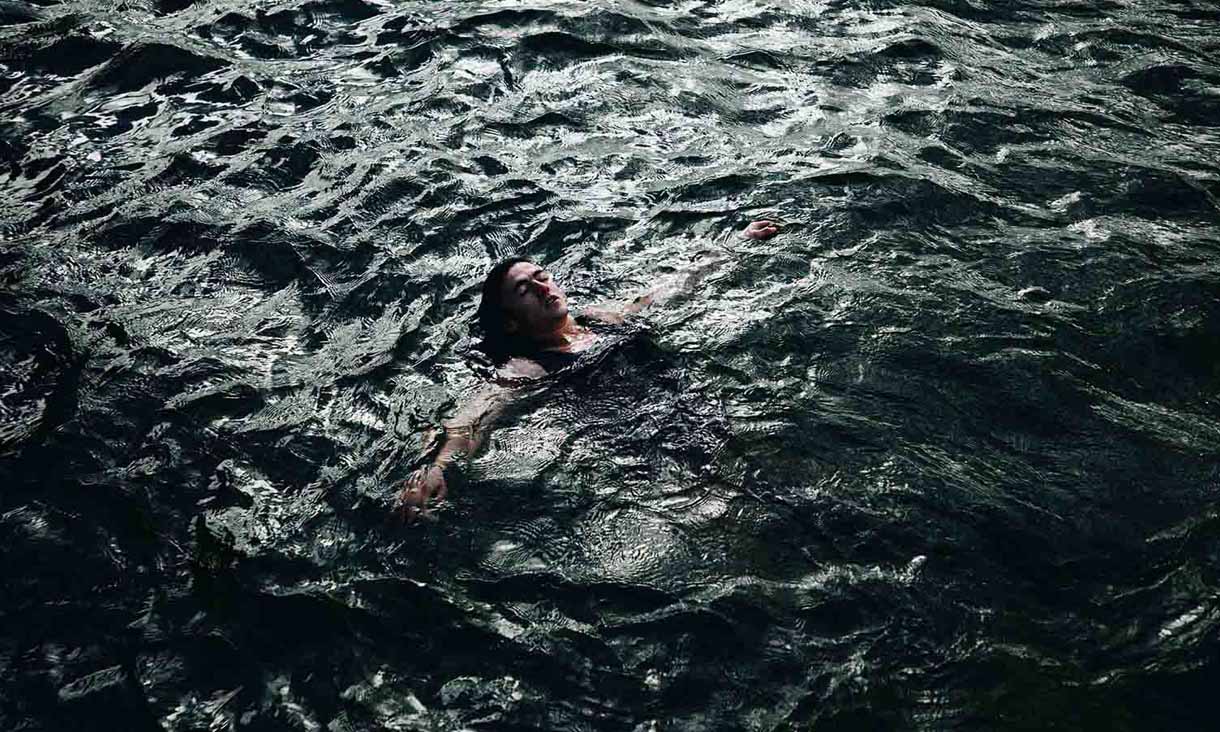 A person floats in turbulent water.