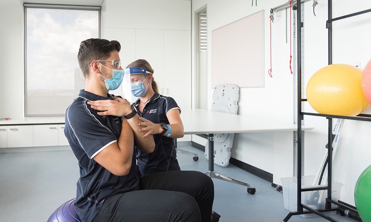 Two RMIT physiotherapy students practice in a clinical setting.
