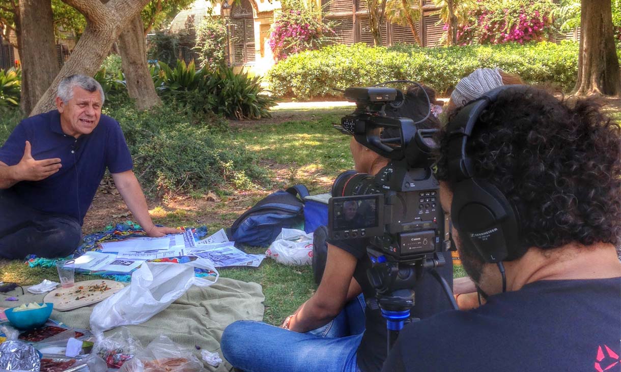 An RMIT student films another student interviewing a man outdoors.