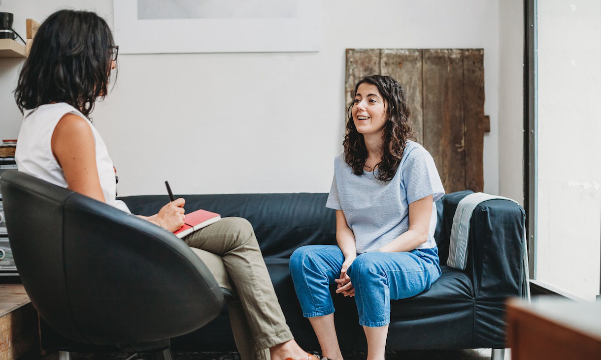 A psychologist listens to a patient in a therapy session.