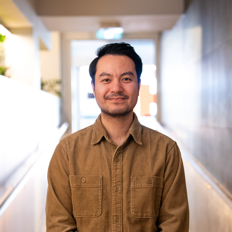 A portrait photograph of Kevin smiling and looking directly at the camera.