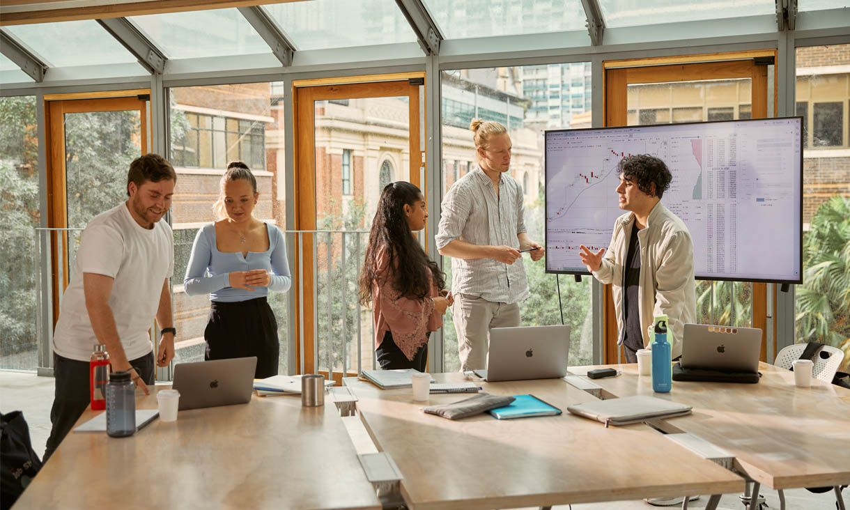 RMIT Business students consult graphs and discuss trends