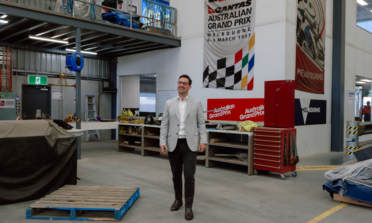 RMIT alumni Dave Carrigan walking through an F1 mechanical workshop