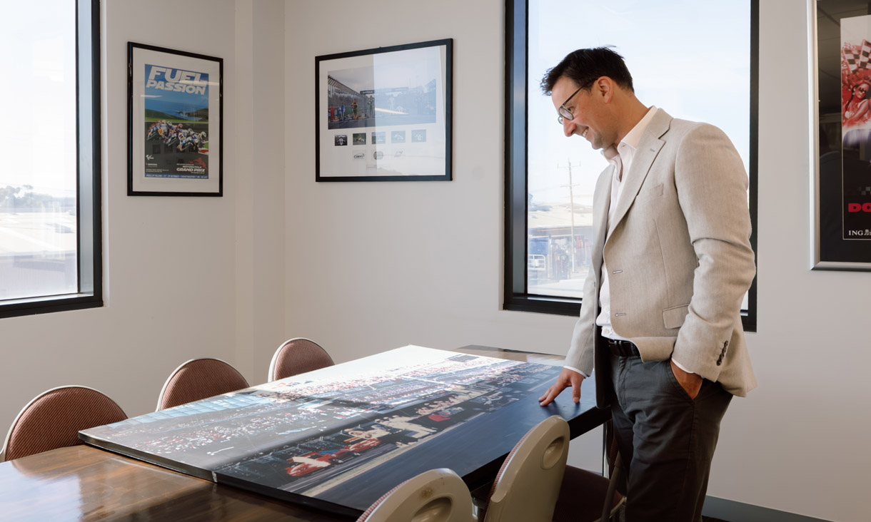 RMIT alumni Dave Carrigan in an office looking down at a large formula 1 printed canvas
