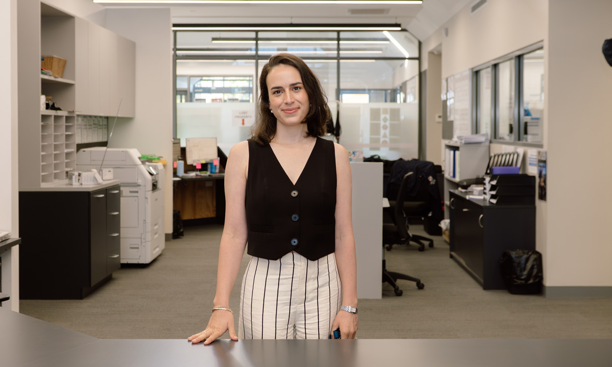RMIT alumni Natalie Gelati standing in an office, smiling at the camera