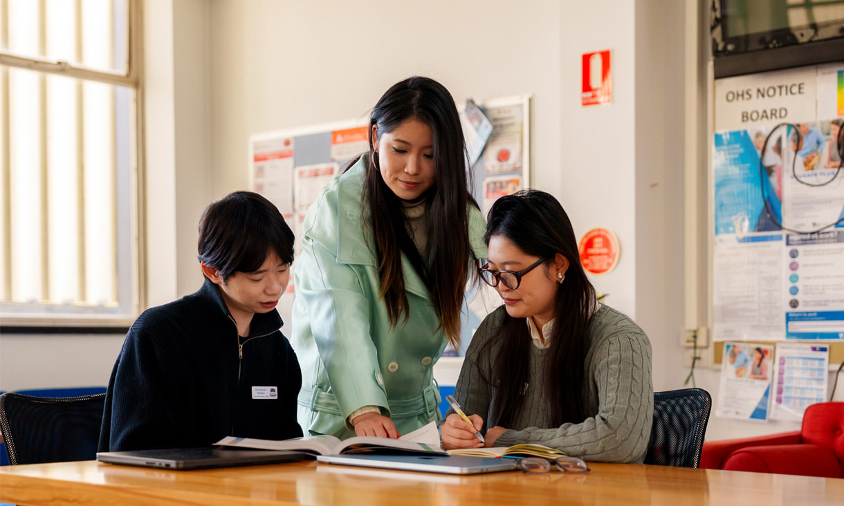 An RMIT Education student and teacher helping a high school student