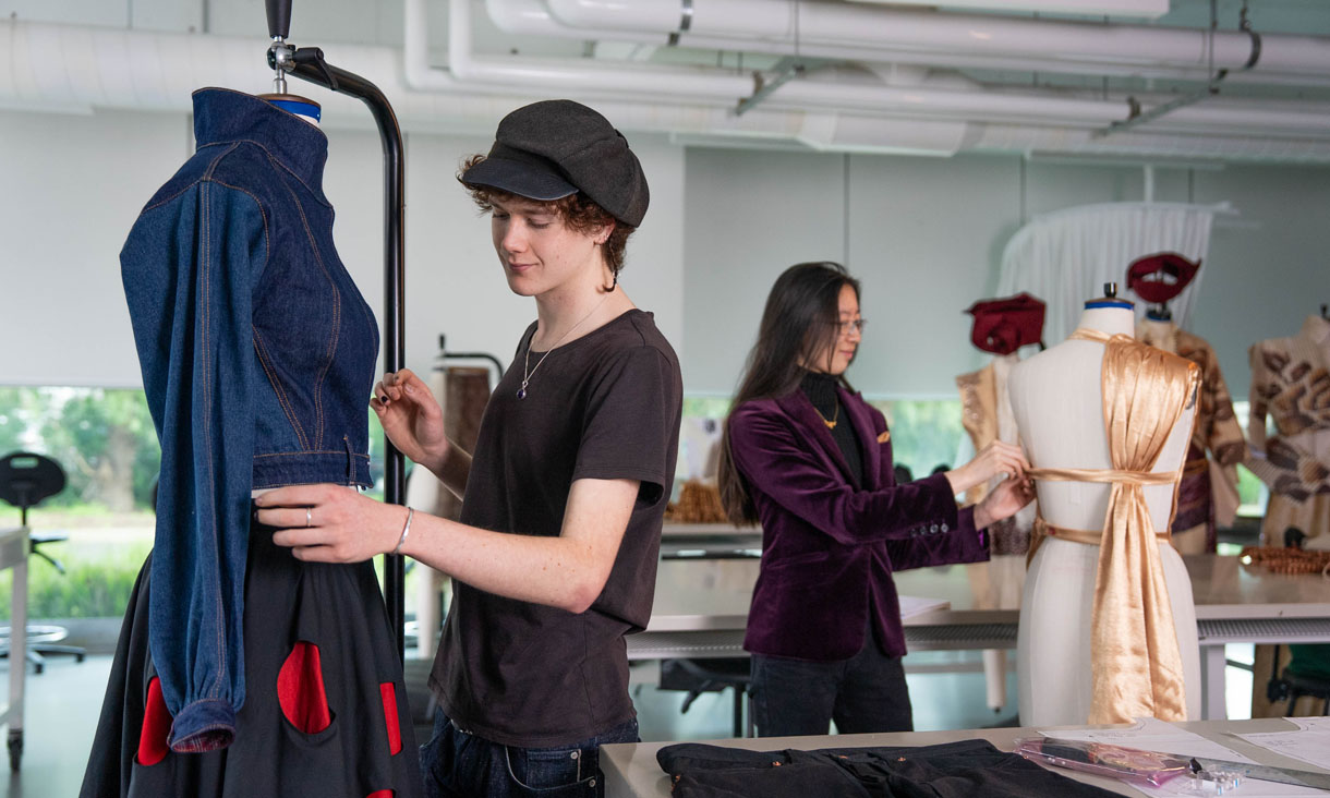 Two RMIT Fashion students working on outfits on mannequinns