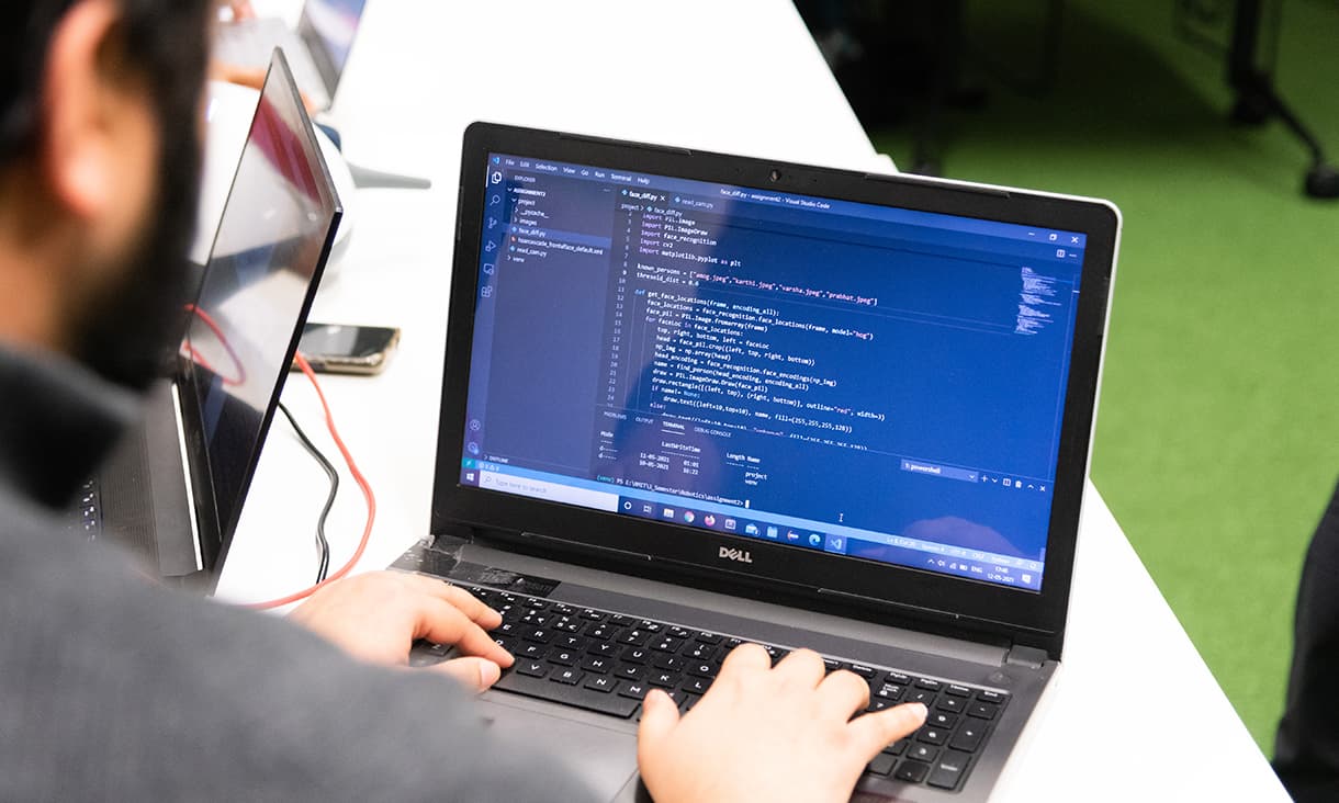 RMIT robotics student coding on laptop