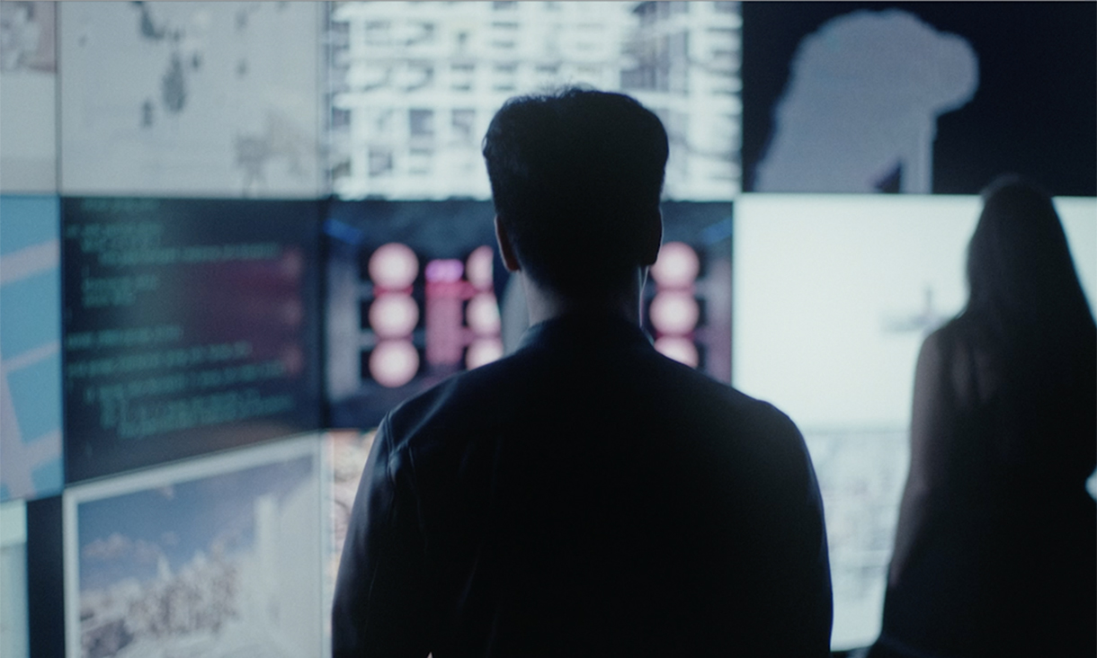 Back of male observing information presented on screens