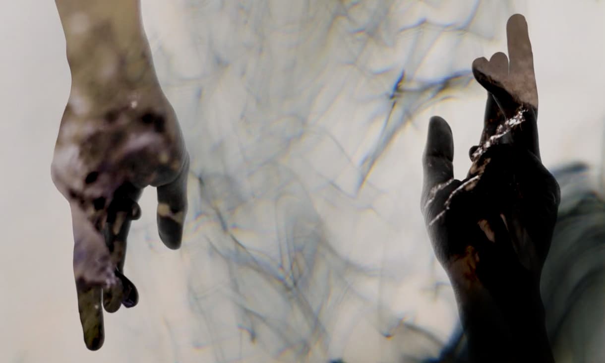 two hands pointing in  opposite direction, surrounded by black smoke