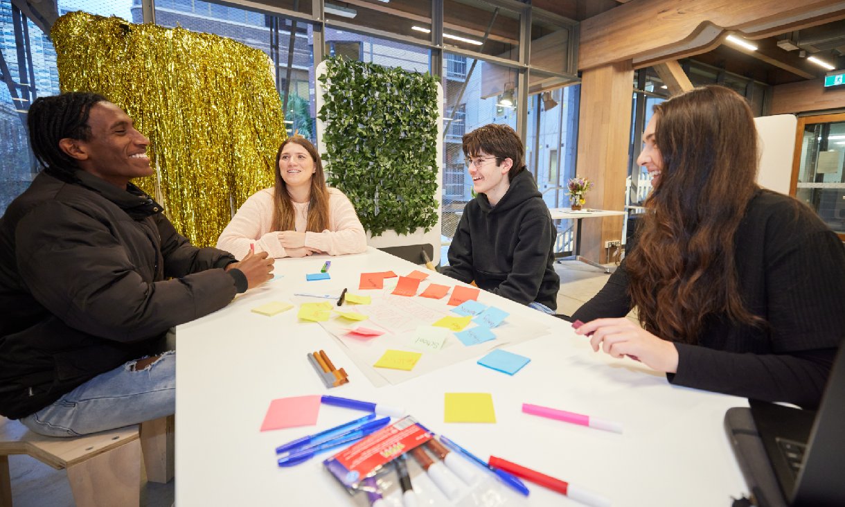 Two RMIT Youth Work students sitting with two high school students