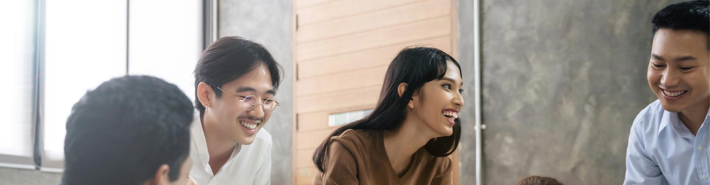 Four international students discussing a topic in a classroom.