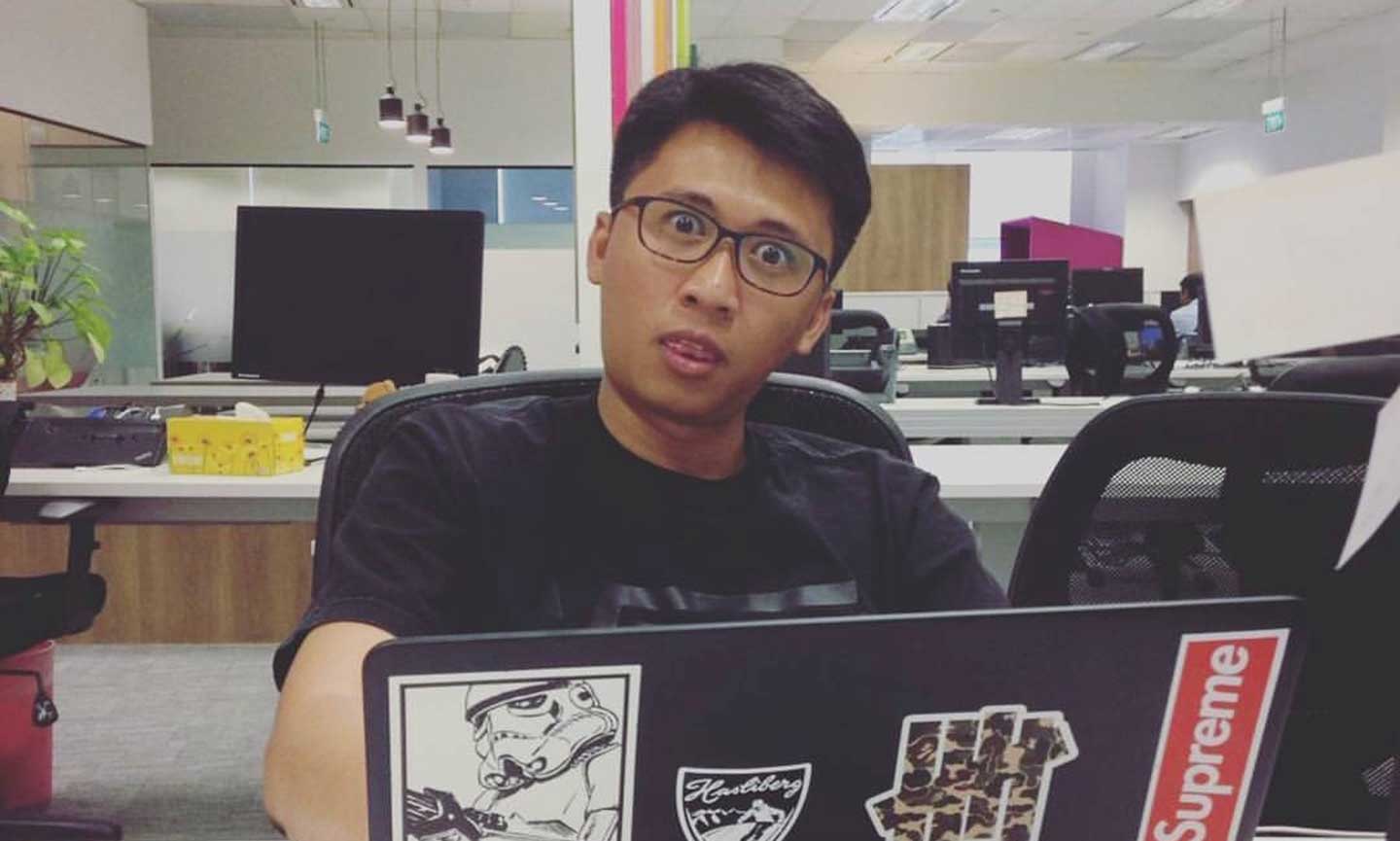 Student sitting at desk with laptop with expression