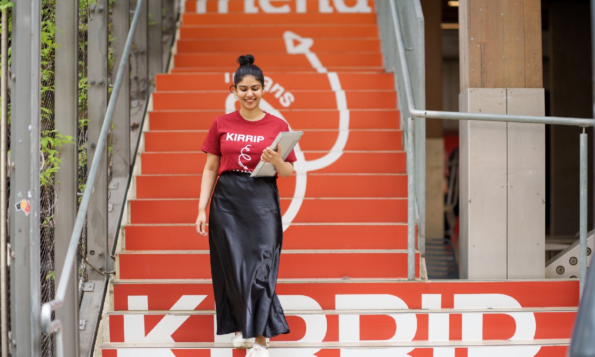 An RMIT Jirrip student walking down a set of orange stairs