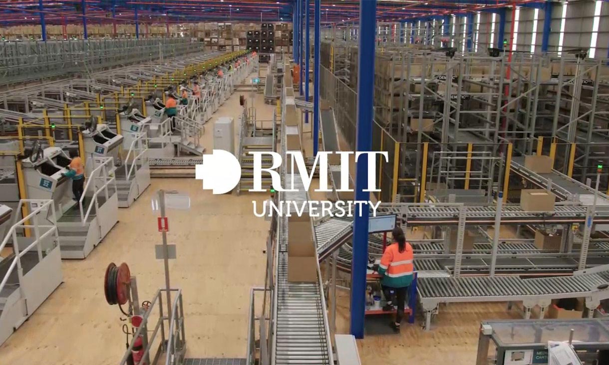 People wearing hi-vis working inside large factory setting with automated processes such as parcels being packed and stored on shelves