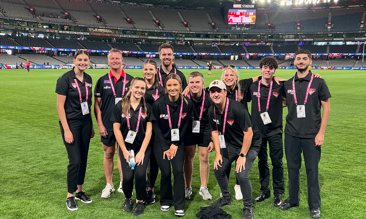 Group of Diploma of Business students standing on the grounds of a stadium