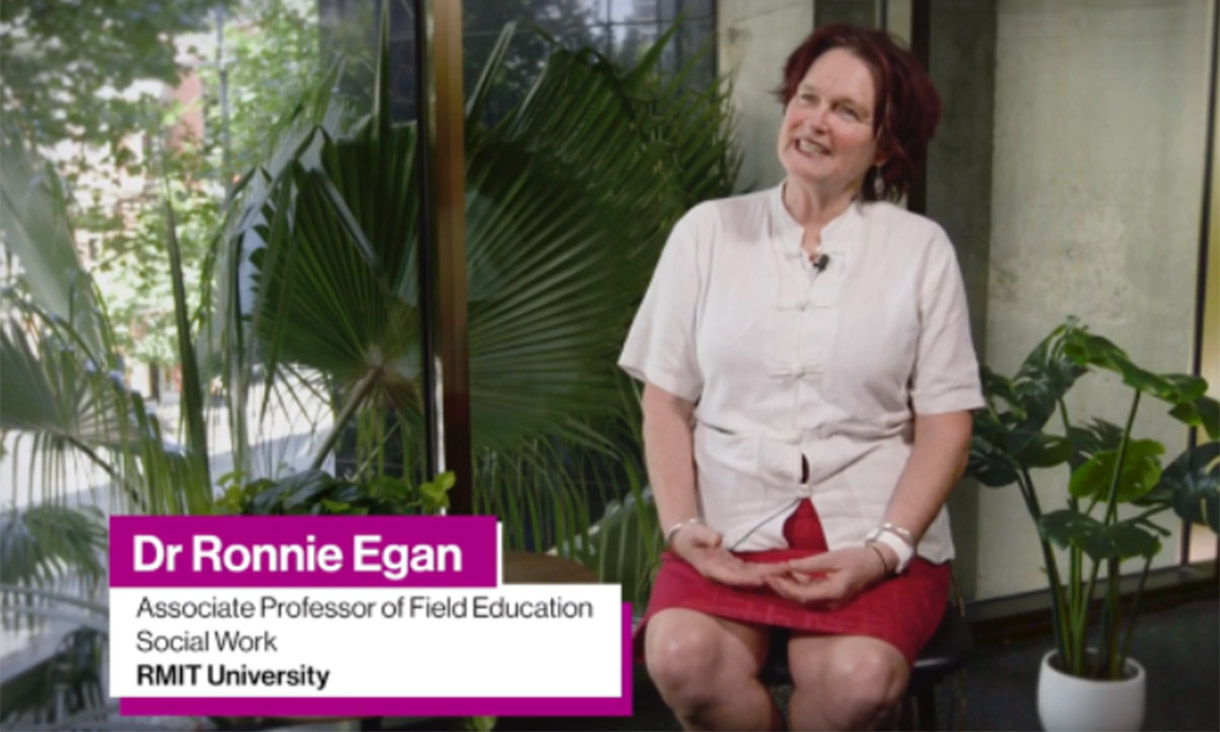 Image of lecturer seated and speaking to camera