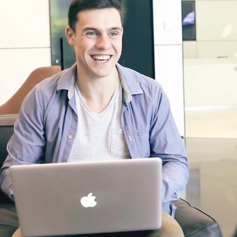 Business student smiling with open laptop