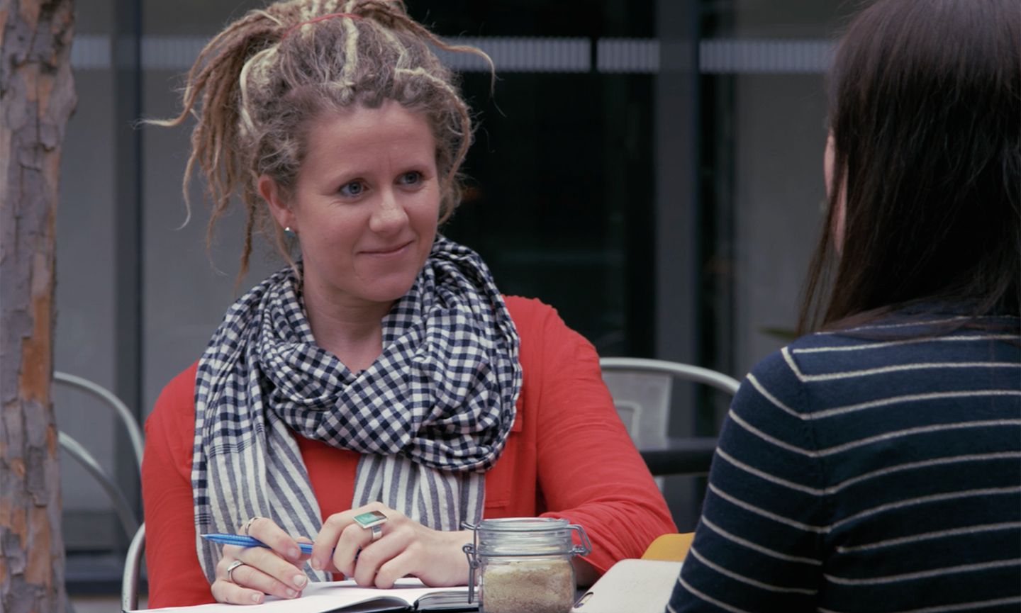Rebecca Paterson sits at cafe with notebook