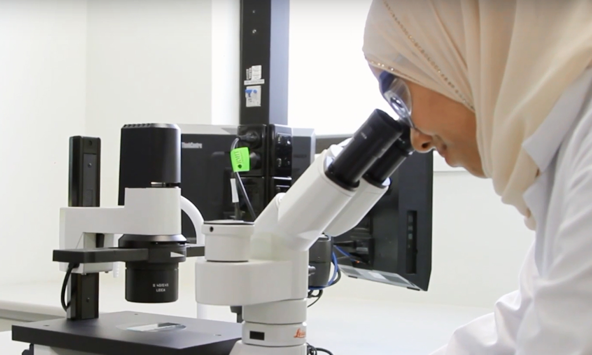 Student looking through a microscope.