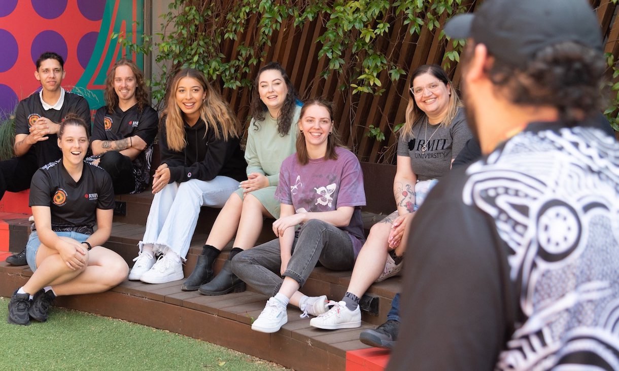 Students sit outside in Ngarara Willim Place on City campus.