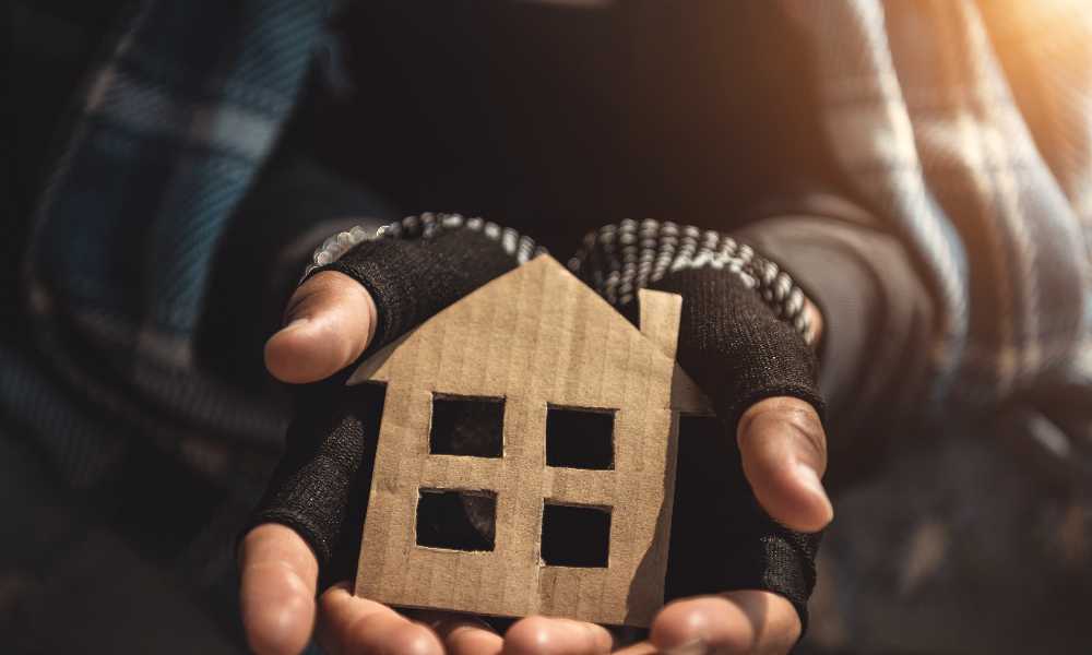 Hands holding carboard cutout of a house