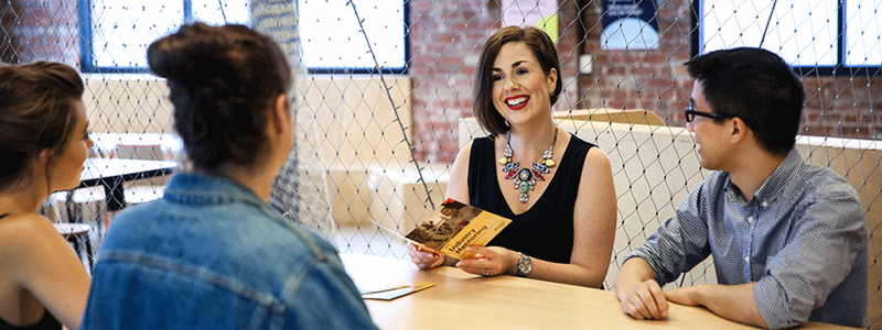 Photograph of four smiling adults seated at a table. 