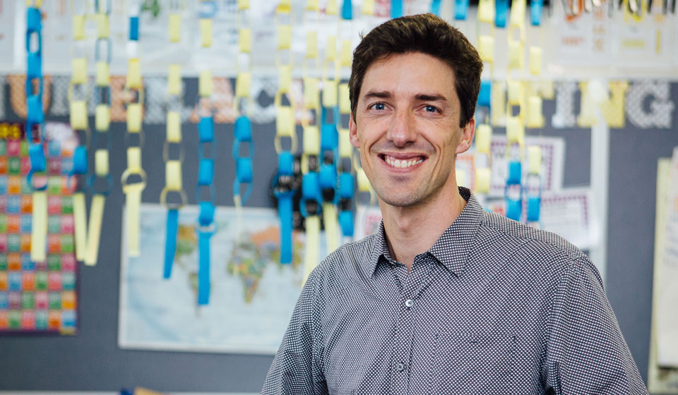 Male primary school teacher, smiling, looking toward camera