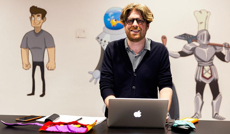 Femalre student wearing glasses reaching out to a stock of art supplies