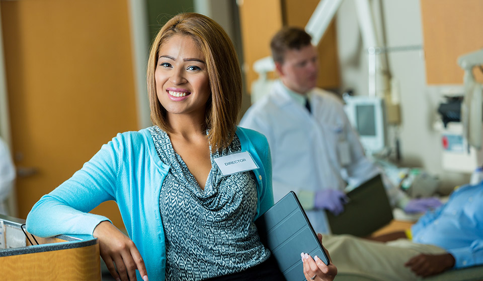 Female holding tablet while leaning against desk