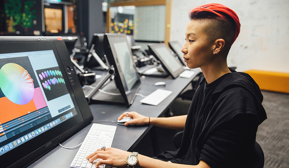 Student working on a large computer screen with intense colour palette