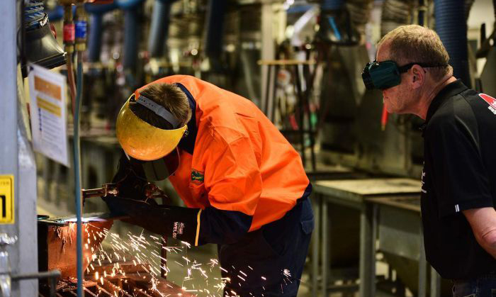  Nathanial Bradford welding as his TAFE teacher Ronald Dyer looks on