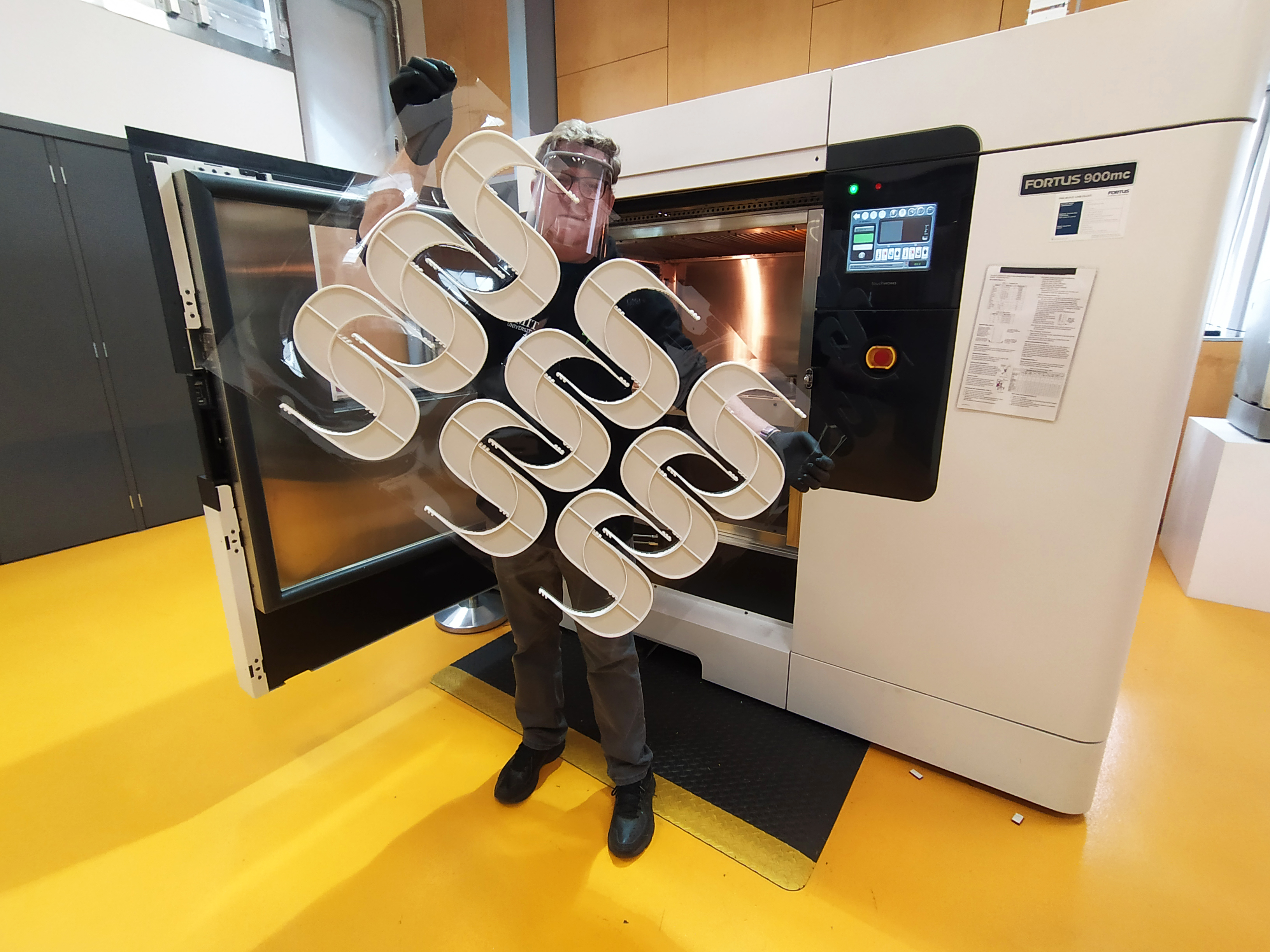 RMIT's Paul Spithill with a batch of the 3D printed plastic face shield frames. 
