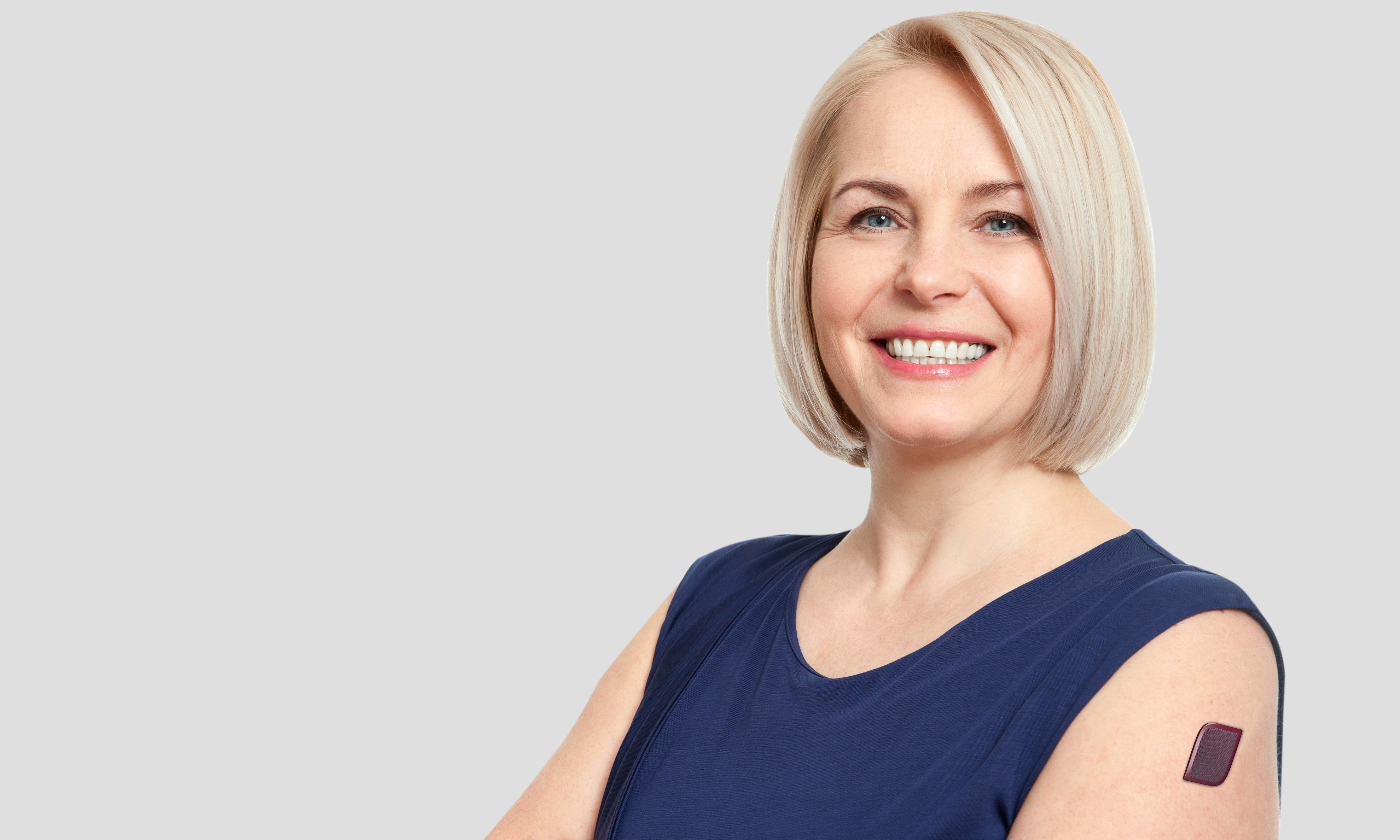Woman smiling and wearing a proof-of-concept smart patch on her arm