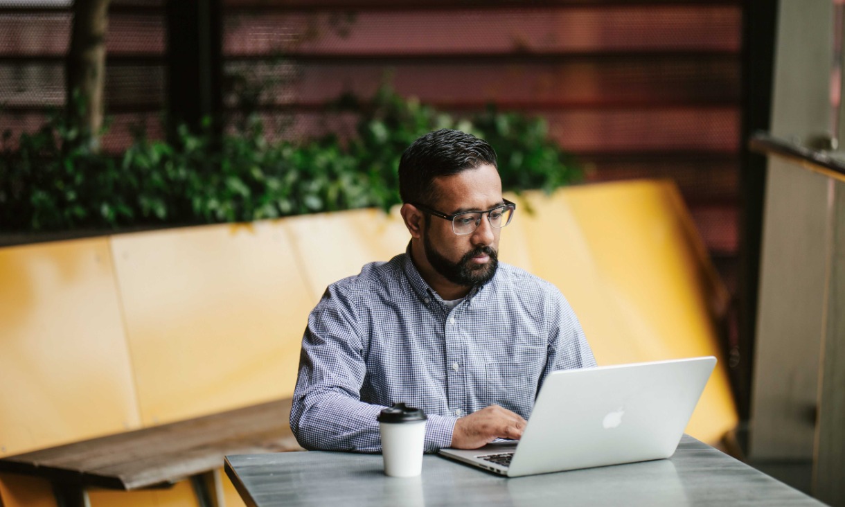 Male student using laptop at Building 80 study space