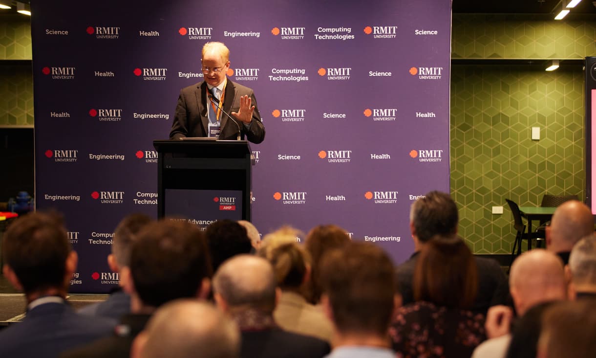 Mark Easton stands at a lectern presenting to an audience.