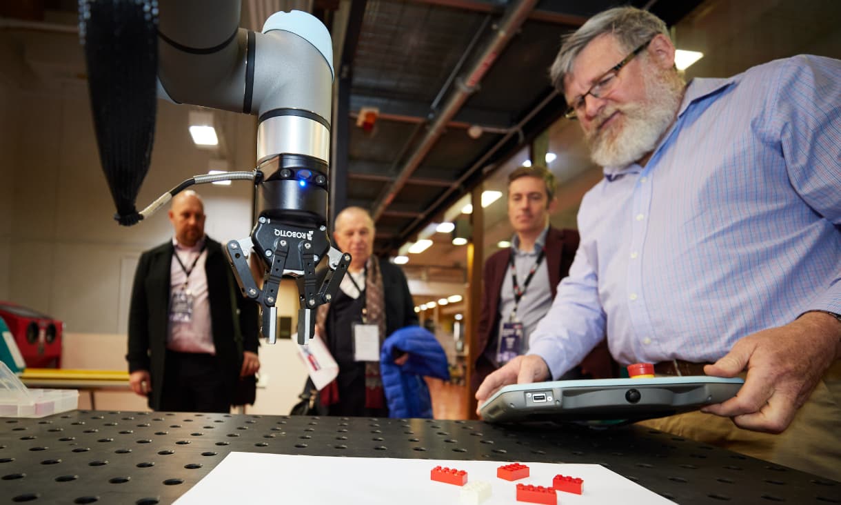 A man shows a group of people something on an iPad.