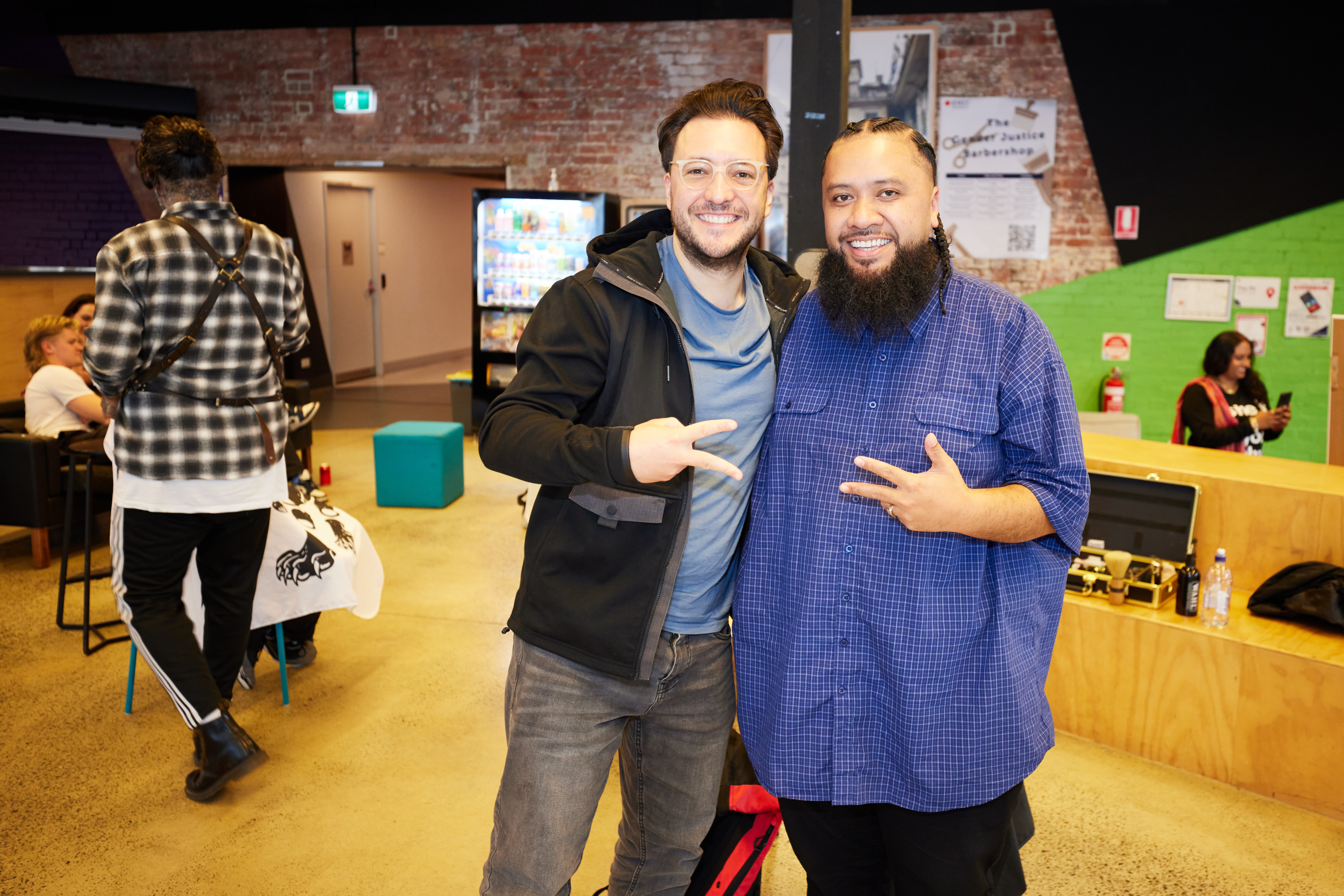 Matt Brown (right) poses towards the camera with a student who has just had their hair cut