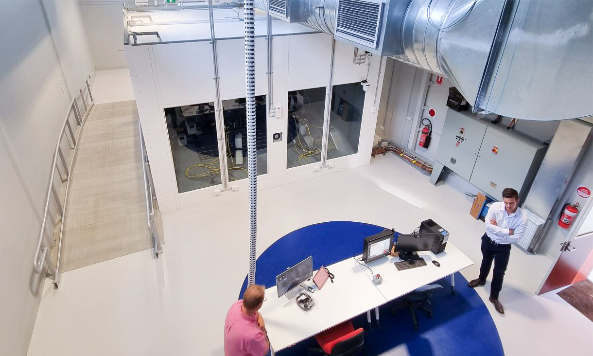 Image taken from above of laboratory with two men standing at a desk