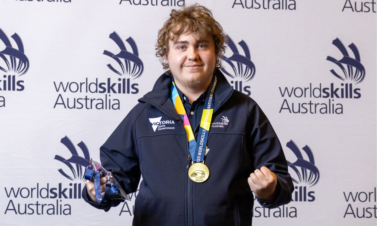 Dylan Armstrong with gold medal, smiling at camera