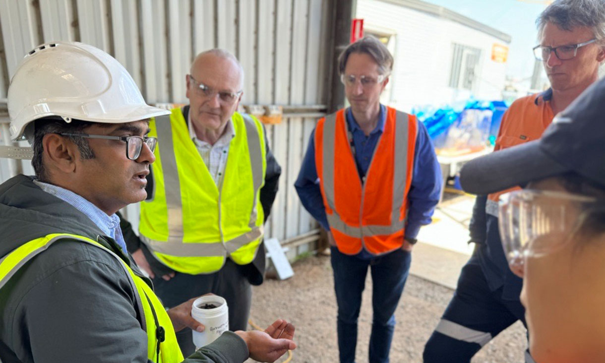 Project lead Professor Kalpit Shah (left) explains to a tour group how the PYROCO pilot unit works. Credit: RMIT University