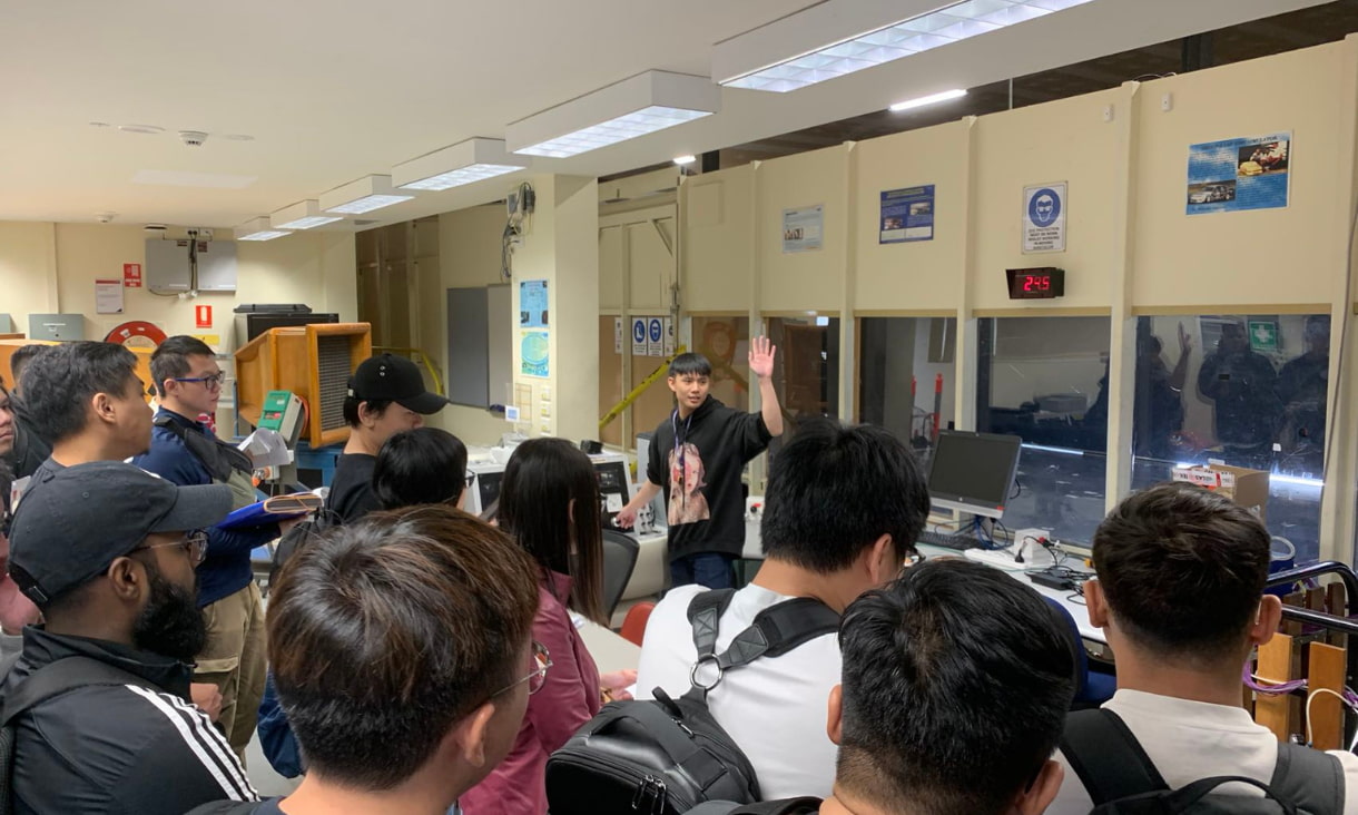 Students stand in a crowd around a presenter in one of RMIT’s laboratories.