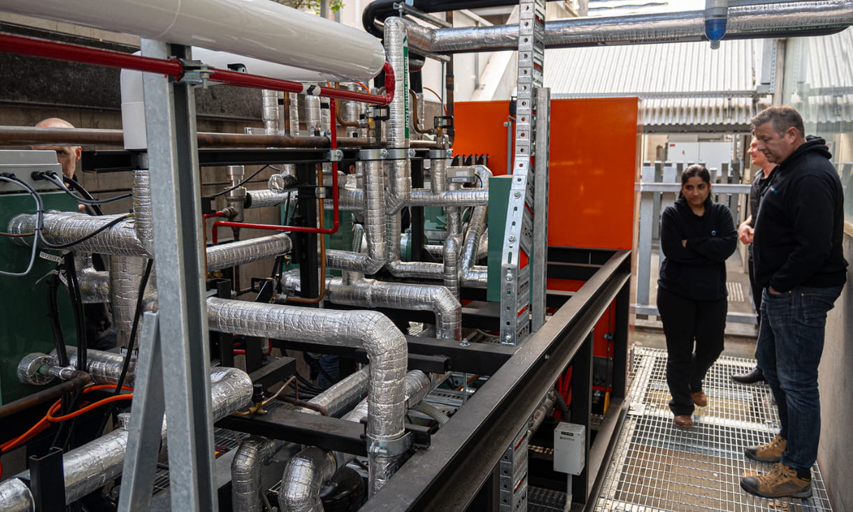 A man and a woman stand in front of a refrigeration system