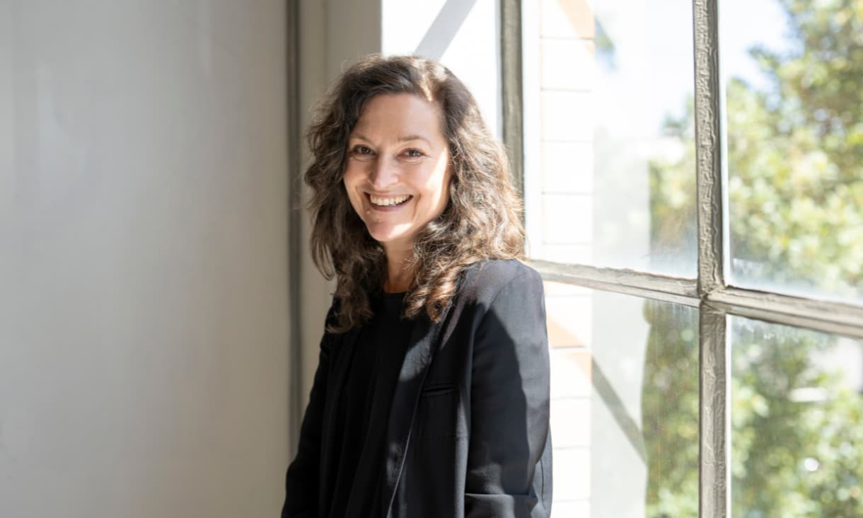 Kerstin Thomson smiling and standing in front of a light filled window