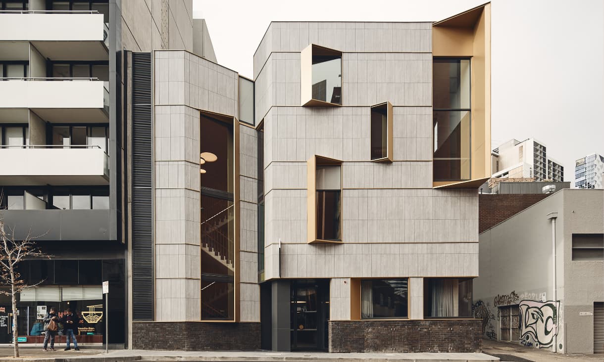 A photo of a grey building taken from across the road