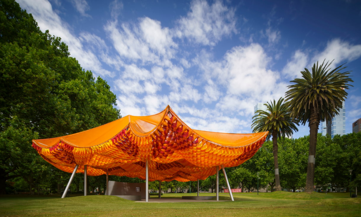 An orange tent standing in a field